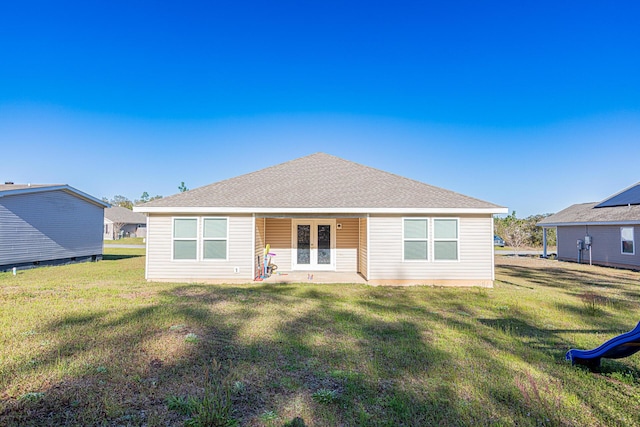 back of house with french doors, a shingled roof, and a lawn