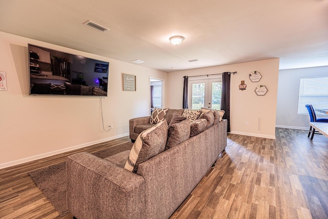 living room with french doors, wood finished floors, baseboards, and visible vents