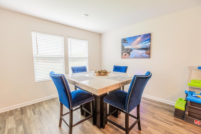 dining space featuring baseboards and wood finished floors