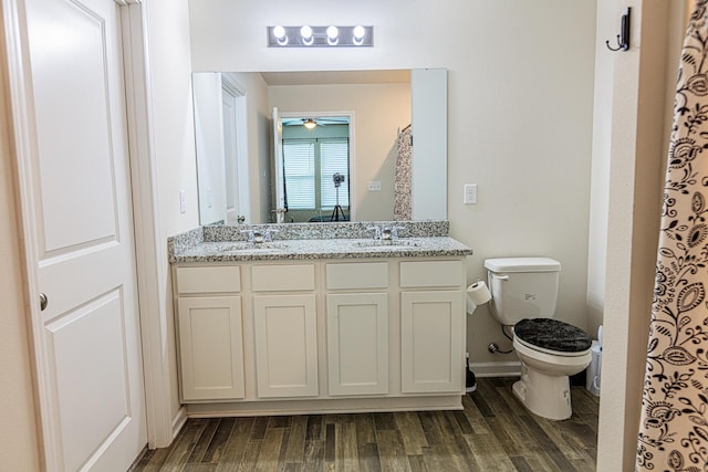 full bathroom with toilet, a sink, and wood finished floors
