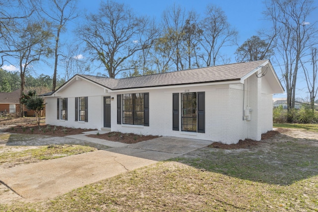 view of front of home featuring a shingled roof and brick siding