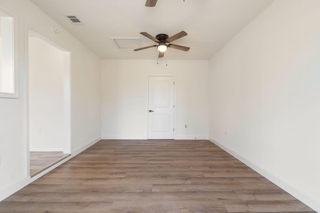 spare room with baseboards, wood finished floors, visible vents, and a ceiling fan