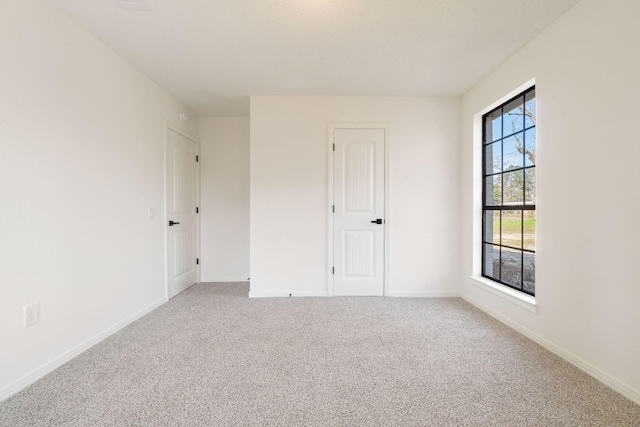 spare room featuring carpet and baseboards