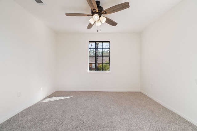 empty room with baseboards, ceiling fan, visible vents, and carpet flooring