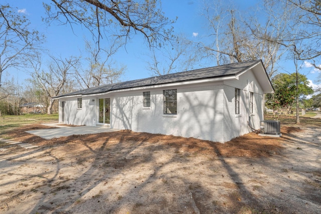 view of property exterior with a patio area, brick siding, and central AC unit