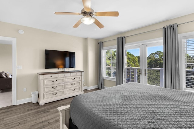 bedroom featuring ceiling fan, multiple windows, baseboards, and wood finished floors