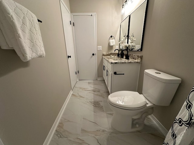 bathroom featuring baseboards, toilet, marble finish floor, and vanity