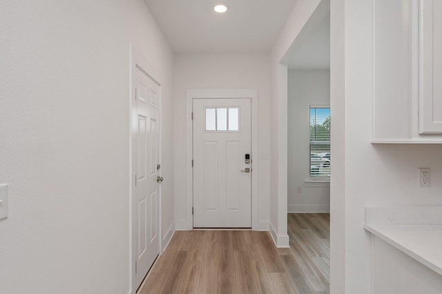 foyer featuring light wood-style flooring and baseboards