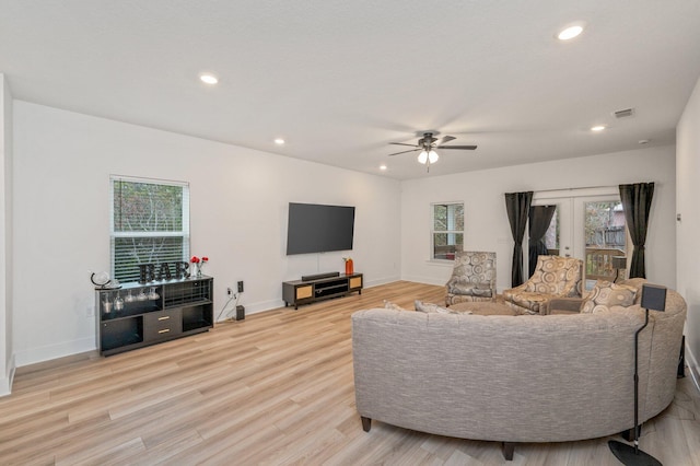 living room with recessed lighting, french doors, a wealth of natural light, and wood finished floors