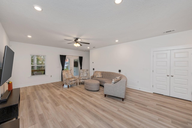 living room with light wood-style flooring, visible vents, and recessed lighting