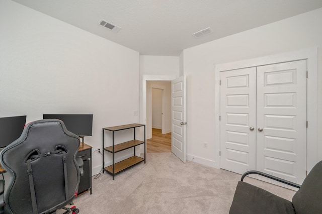 office featuring light colored carpet, visible vents, and baseboards