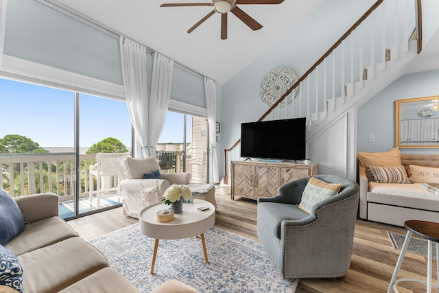 living area featuring ceiling fan, high vaulted ceiling, stairway, and wood finished floors