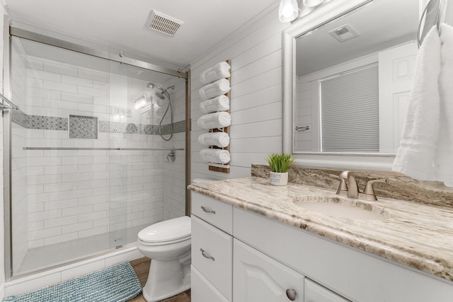 full bathroom with toilet, a stall shower, vanity, and visible vents