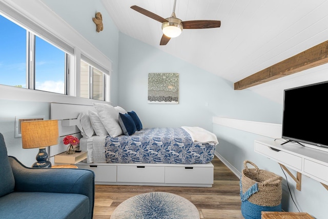 bedroom featuring a ceiling fan, lofted ceiling with beams, and wood finished floors