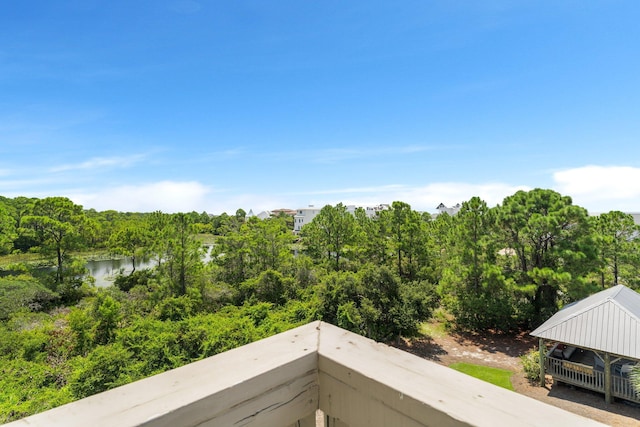 balcony featuring a water view and a forest view