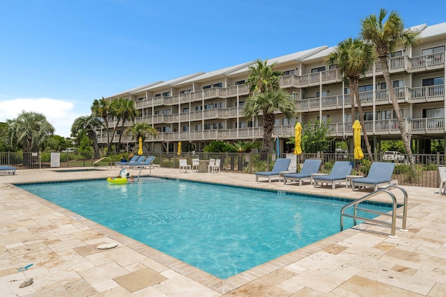 community pool featuring a patio area and fence