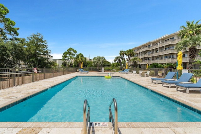 community pool featuring a patio area and fence