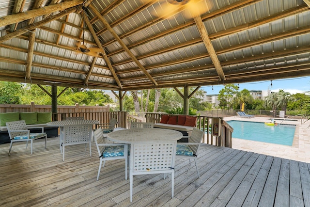 wooden deck with fence, outdoor dining area, a fenced in pool, and a gazebo