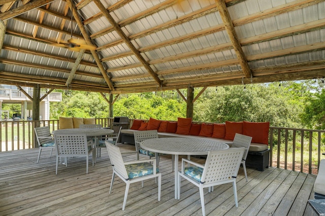 wooden terrace featuring a gazebo and outdoor dining area