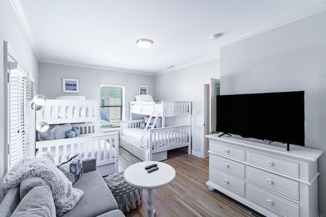 bedroom featuring wood finished floors and ornamental molding