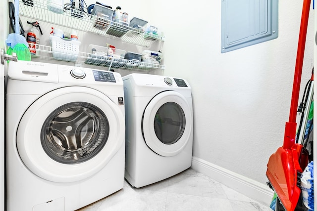 laundry room featuring electric panel, laundry area, baseboards, and separate washer and dryer