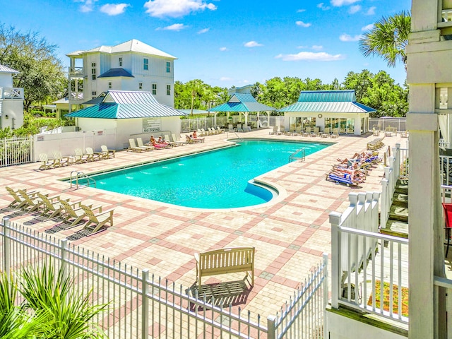 pool featuring fence and a patio area