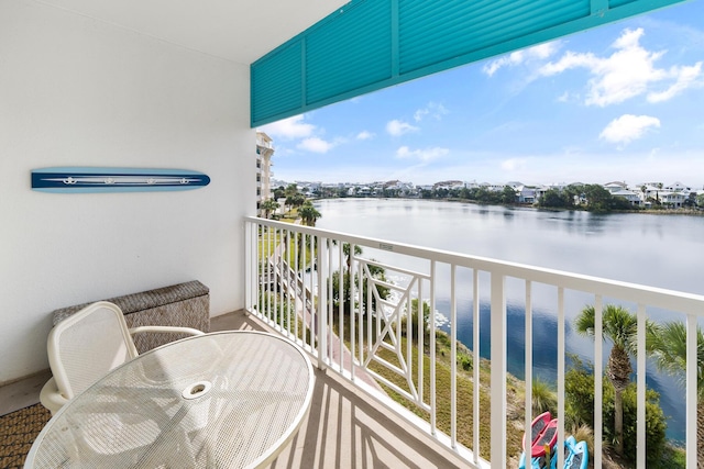 balcony featuring outdoor dining space and a water view