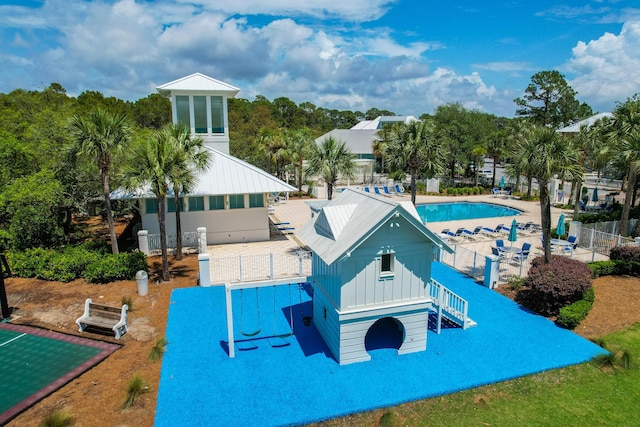 surrounding community with a pool, fence, and a patio