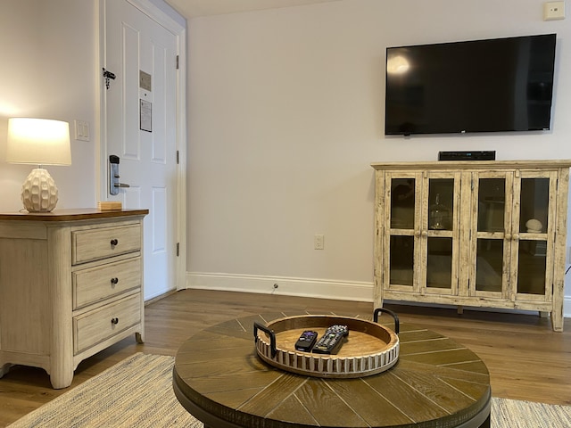 living area with baseboards and wood finished floors