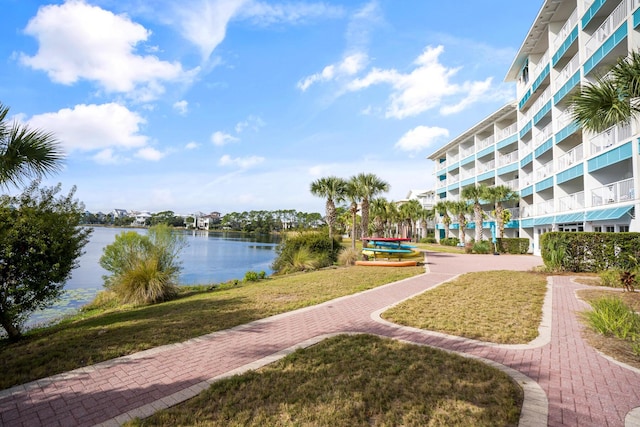 view of property's community with a water view and a yard