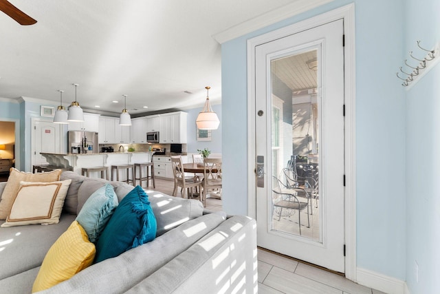 living area with recessed lighting, crown molding, baseboards, and ceiling fan