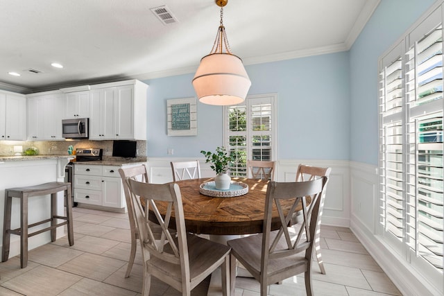 dining area with visible vents, wainscoting, ornamental molding, a decorative wall, and recessed lighting