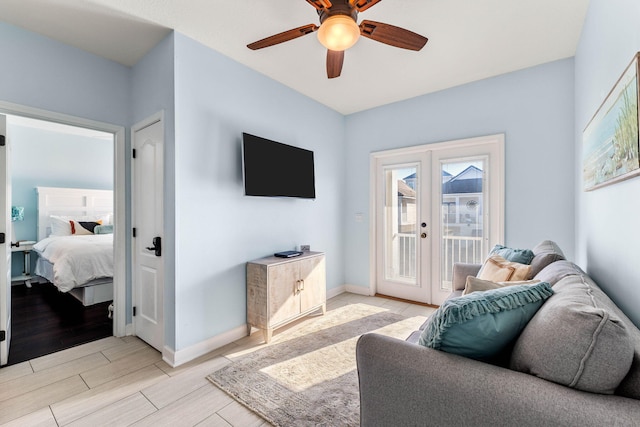 living room featuring wood tiled floor, french doors, ceiling fan, and baseboards