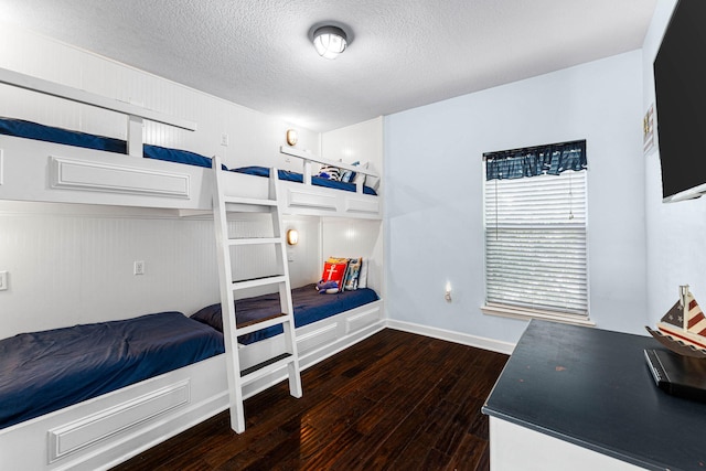 bedroom featuring hardwood / wood-style flooring, baseboards, and a textured ceiling