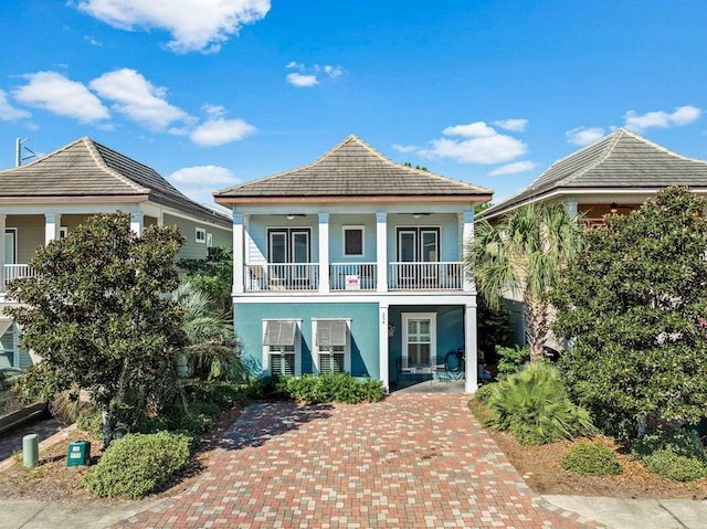 view of front of home featuring ceiling fan, a balcony, and stucco siding