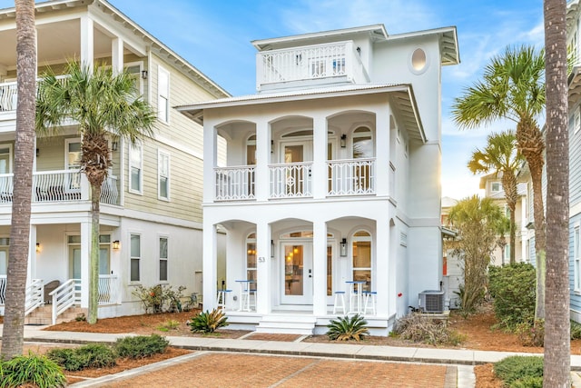 view of front of home featuring a porch, central AC, a balcony, and stucco siding