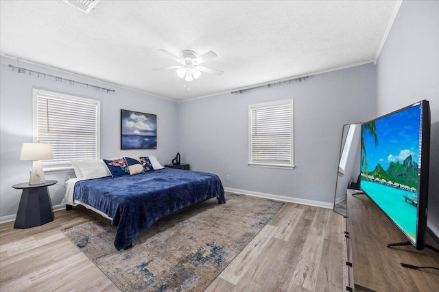 bedroom with baseboards, a textured ceiling, and wood finished floors