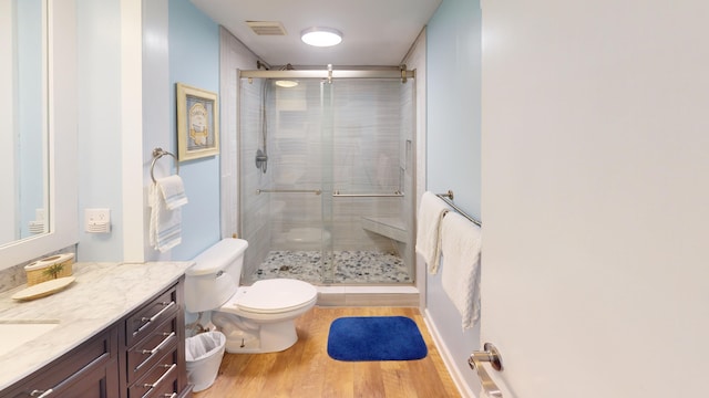 full bathroom with toilet, wood finished floors, vanity, visible vents, and a shower stall