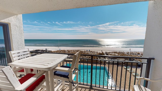 balcony featuring a beach view and a water view