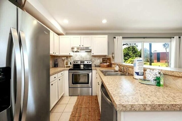 kitchen with light tile patterned floors, decorative backsplash, light countertops, under cabinet range hood, and appliances with stainless steel finishes