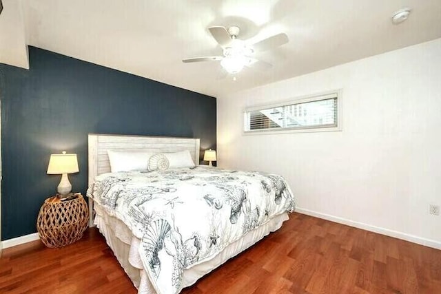 bedroom with ceiling fan, baseboards, and wood finished floors