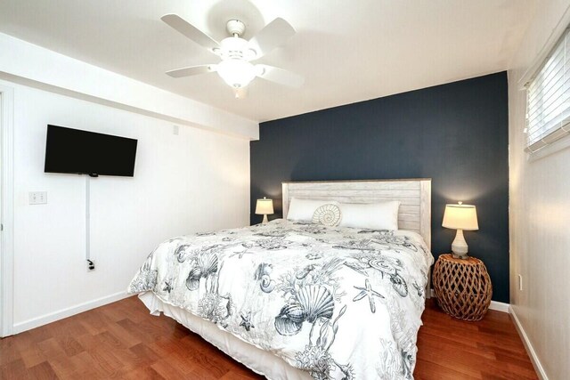 bedroom featuring wood finished floors, baseboards, and ceiling fan