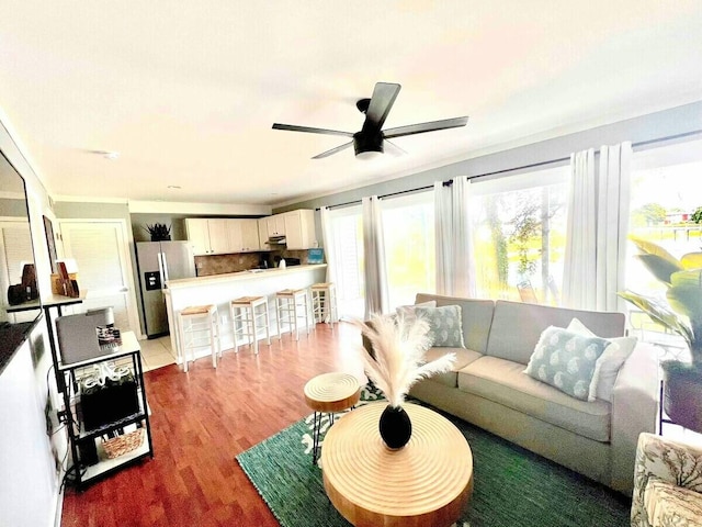 living area featuring light wood-style flooring and a ceiling fan