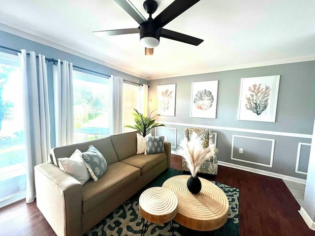 living area featuring baseboards, wood finished floors, a ceiling fan, and ornamental molding