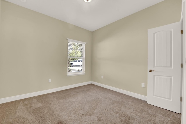 unfurnished room featuring carpet and baseboards