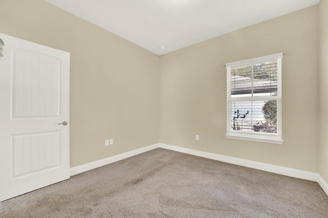 carpeted spare room featuring baseboards