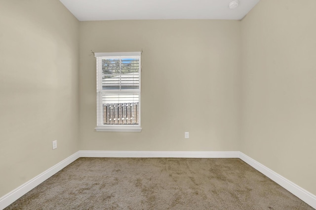 carpeted spare room featuring baseboards