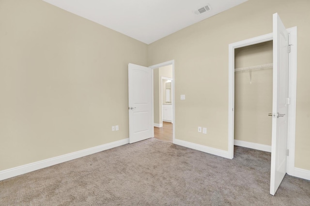 unfurnished bedroom featuring carpet, a closet, visible vents, and baseboards