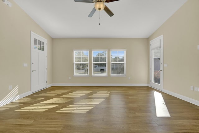 empty room featuring ceiling fan, wood finished floors, and baseboards