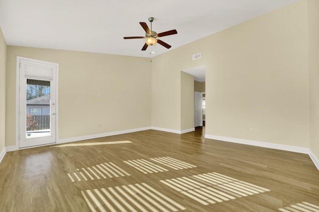 spare room featuring baseboards and wood finished floors